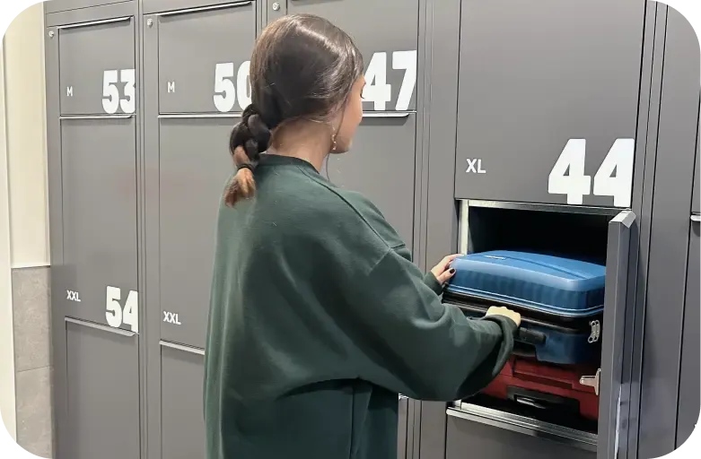 Chica guardando sus maletas en una taquilla
